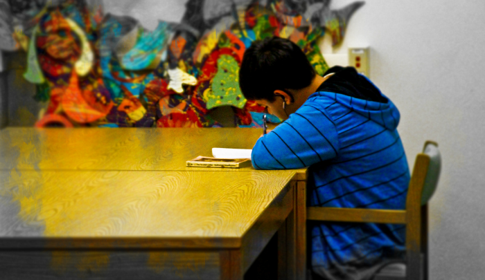 child sitting at a table doing homework