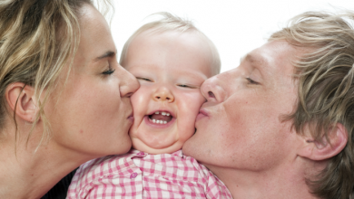 Mom and Dad kissing a babies cheeks