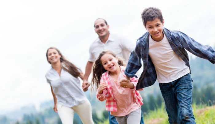 Mother and Father holding hands and brother and sister holding hands and running together