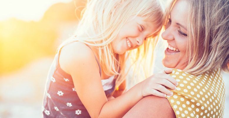 Happy mother holding small daughter in her arms