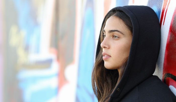Teen girl dressed in black staring off into the distance