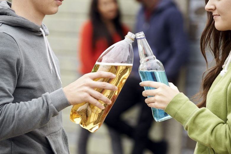 Two teenagers toasting and about to drink alcohol