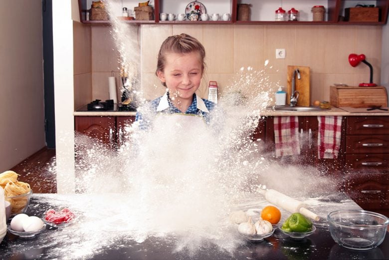 Little girl cooking in the kitchen and making a very big mess