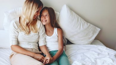 Mother and Daughter sitting on the bed together talking and smiling